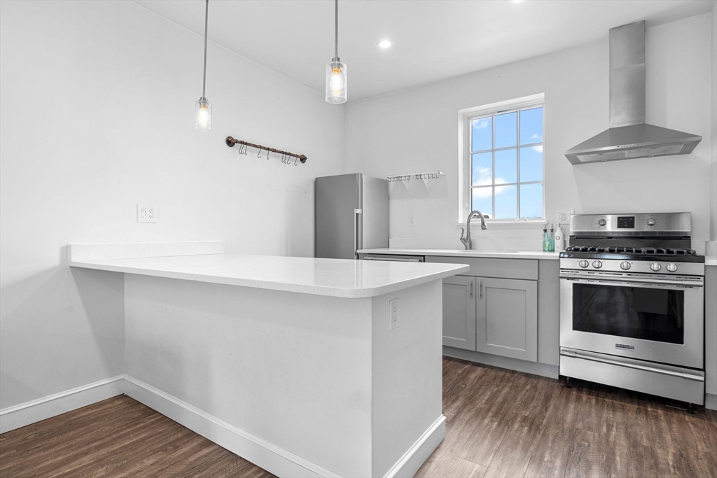 105 Broadway, Unit 2 Chelsea, MA 02150 - Photo 2 of 9 a kitchen with a stove and a white kitchen
