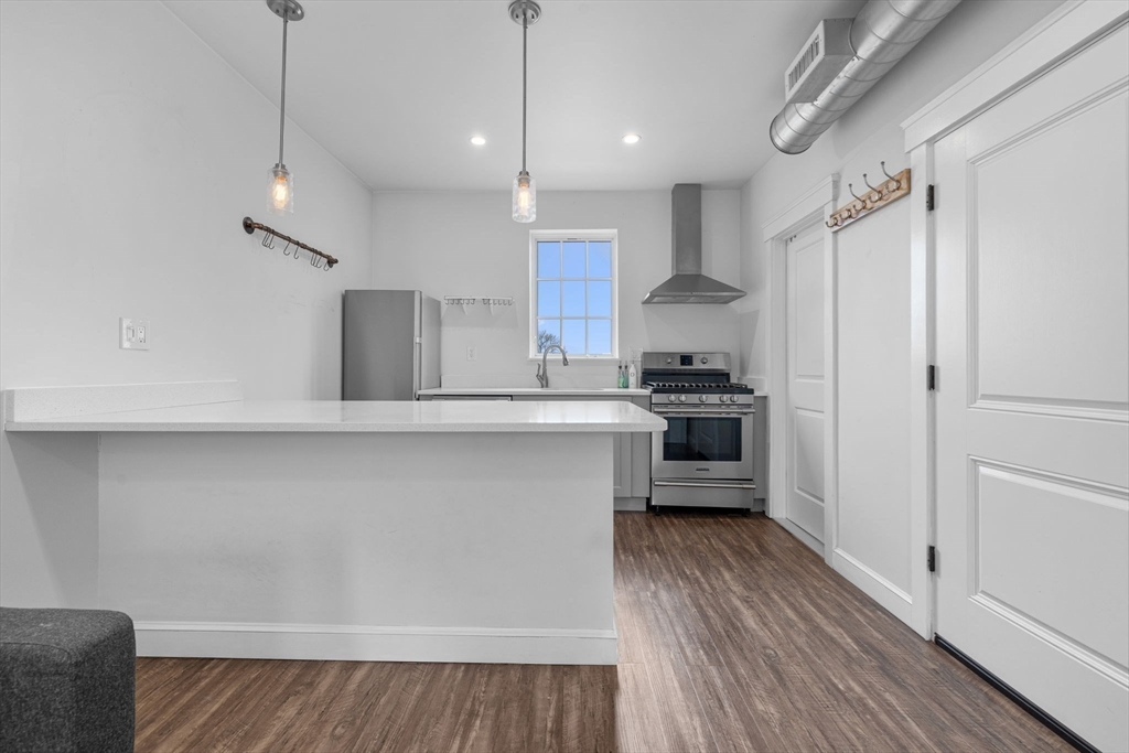 105 Broadway, Unit 2 Chelsea, MA 02150 - Photo 9 of 9 a kitchen with stainless steel appliances a refrigerator and a stove top oven