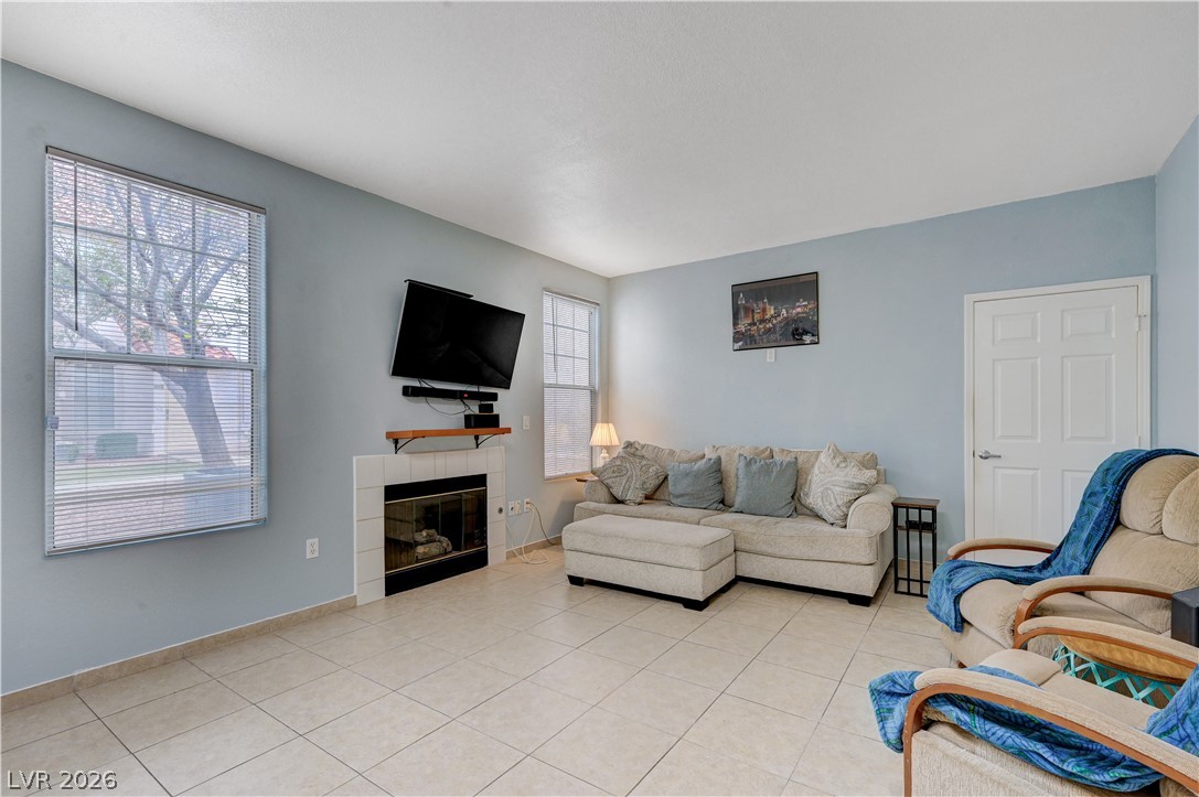 8555 West Russell Road, Unit 1017 Las Vegas, NV 89113 - Photo 2 of 34 A comforting living area with a fireplace and large window, offering a sense of warmth and natural illumination.