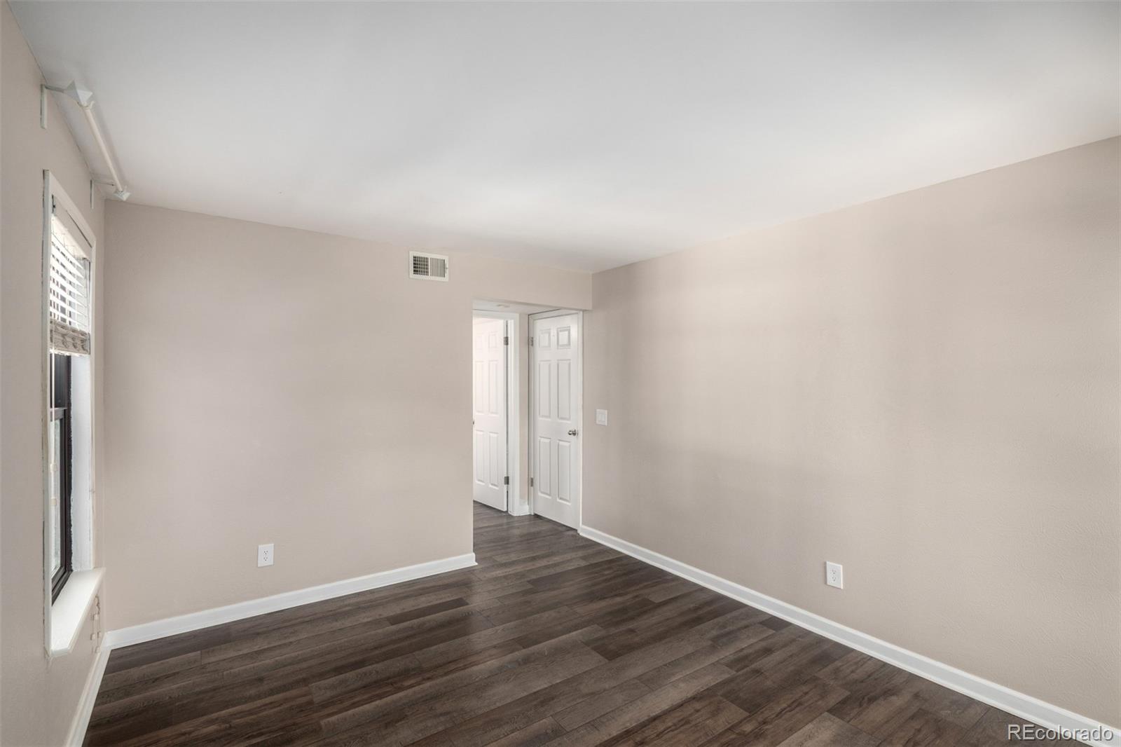 4896 South Dudley Street, Unit 910 Littleton, CO 80123 - Photo 17 of 30 a view of an empty room with wooden floor and a window