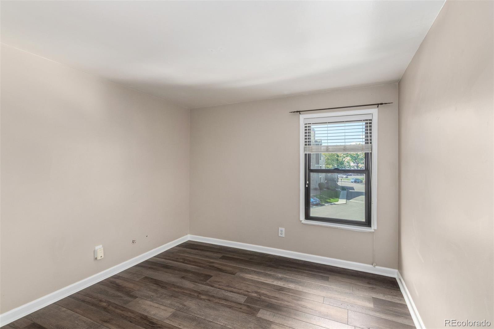 4896 South Dudley Street, Unit 910 Littleton, CO 80123 - Photo 22 of 30 an empty room with wooden floor and windows