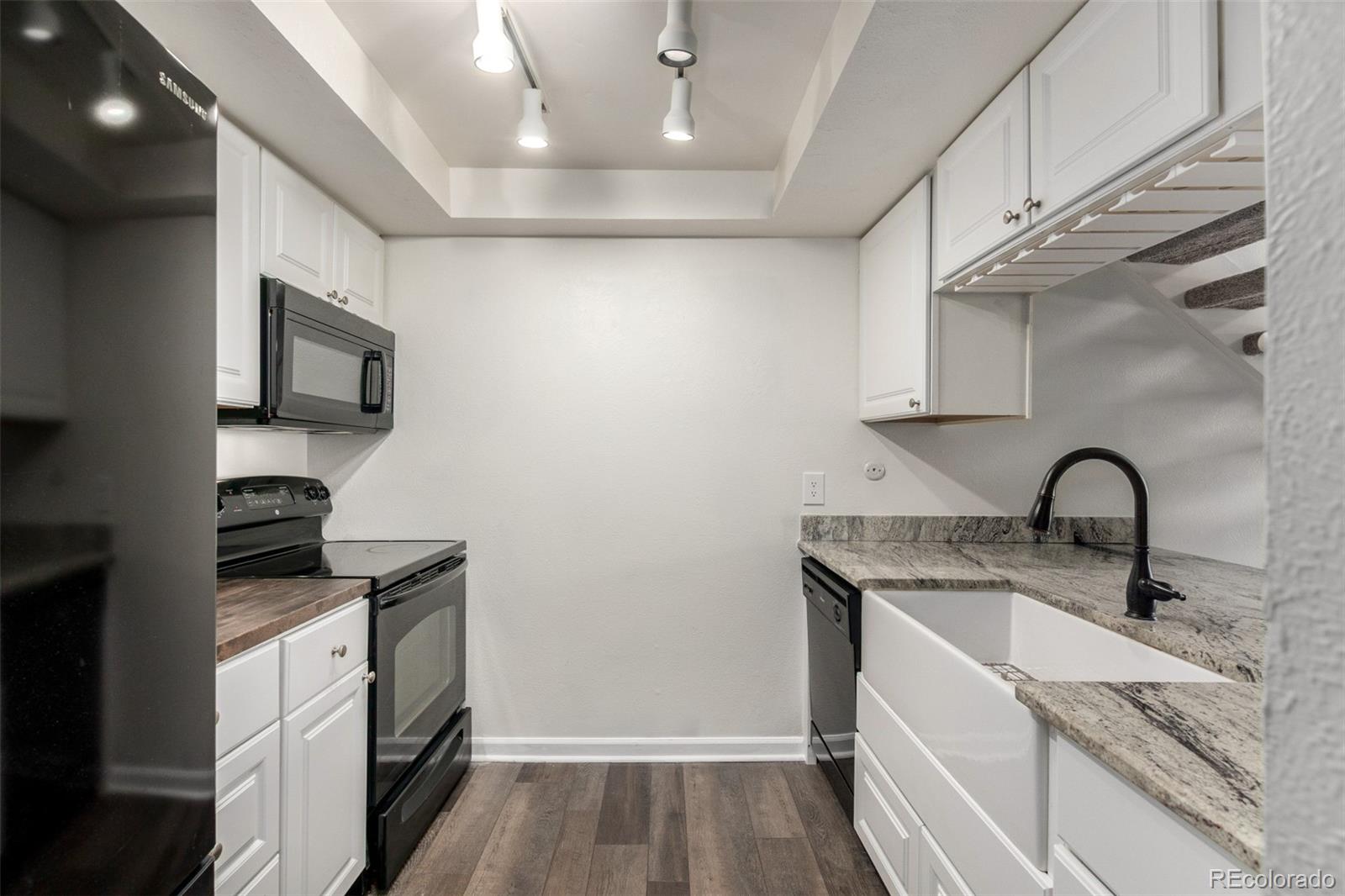 4896 South Dudley Street, Unit 910 Littleton, CO 80123 - Photo 4 of 30 a kitchen with stainless steel appliances granite countertop a sink stove and refrigerator