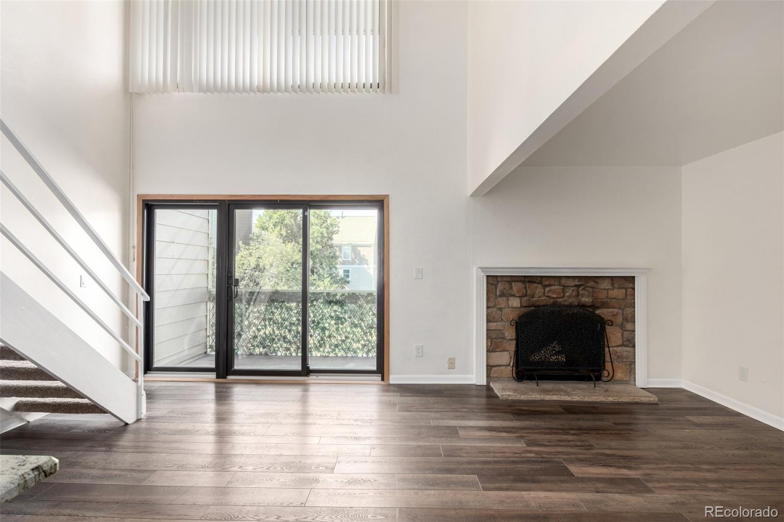 4896 South Dudley Street, Unit 910 Littleton, CO 80123 - Photo 9 of 30 an empty room with wooden floor and fireplace