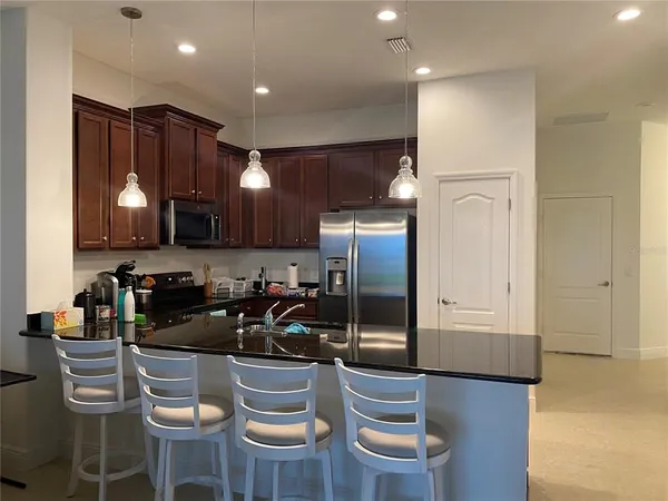 a kitchen with stainless steel appliances granite countertop a refrigerator and a stove top oven