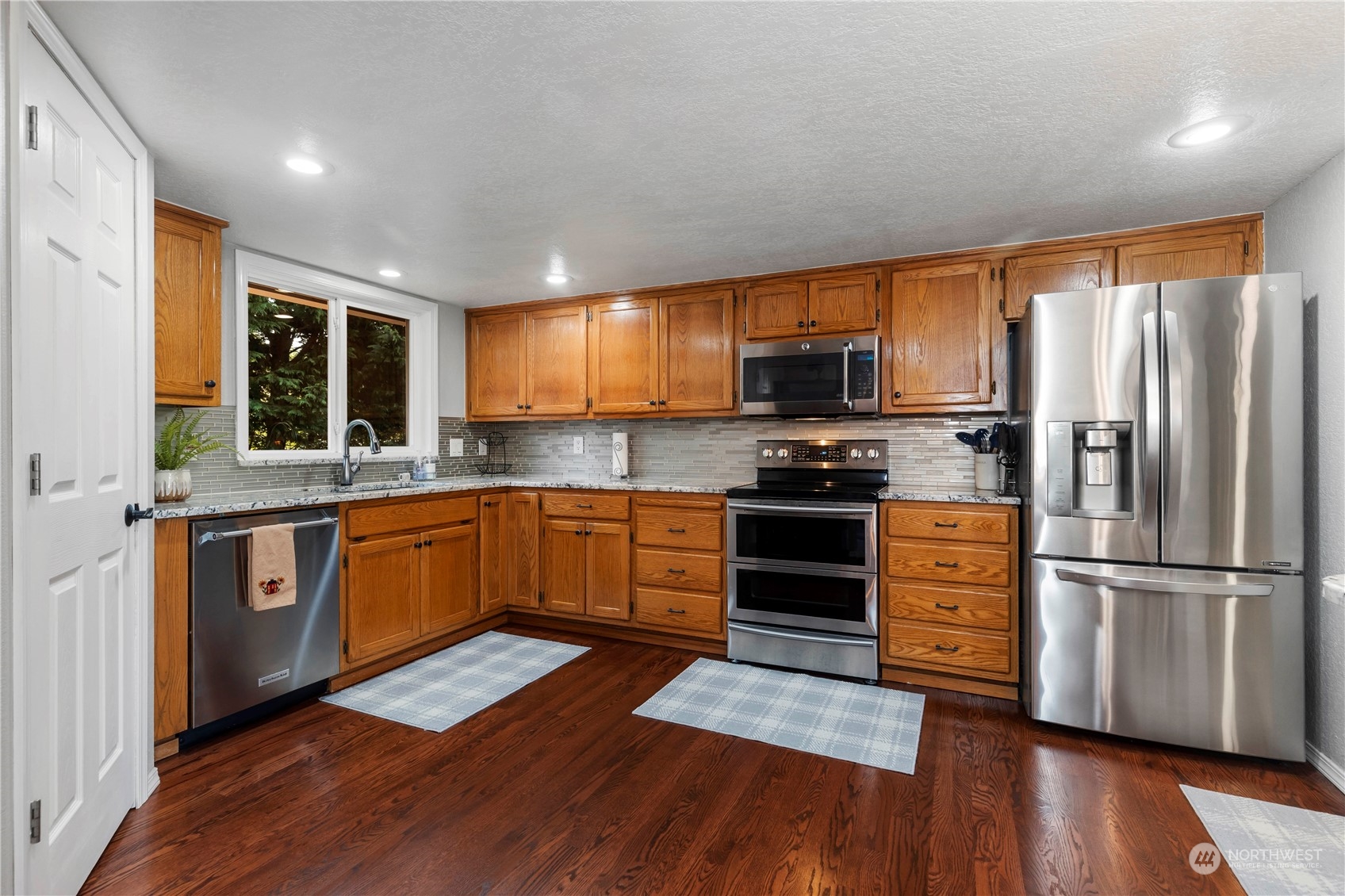 120 221st Street Southwest Bothell, WA 98021 - Photo 13 of 40 a kitchen with stainless steel appliances a stove a sink a refrigerator a window and wooden cabinets