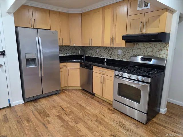 a kitchen with stainless steel appliances granite countertop a stove a refrigerator and a microwave