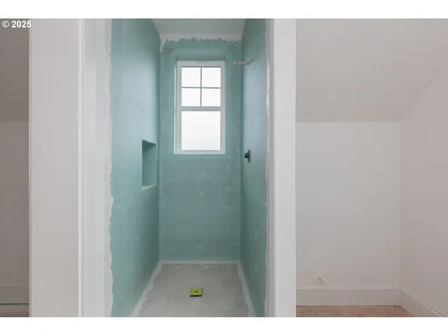 a view of a big room with windows and chandelier fan