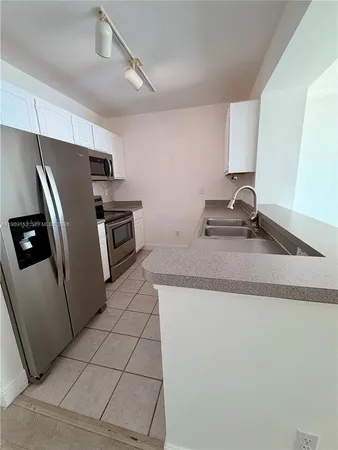 a kitchen with granite countertop a refrigerator and a sink