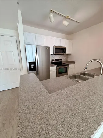 a kitchen with stainless steel appliances a refrigerator sink and microwave