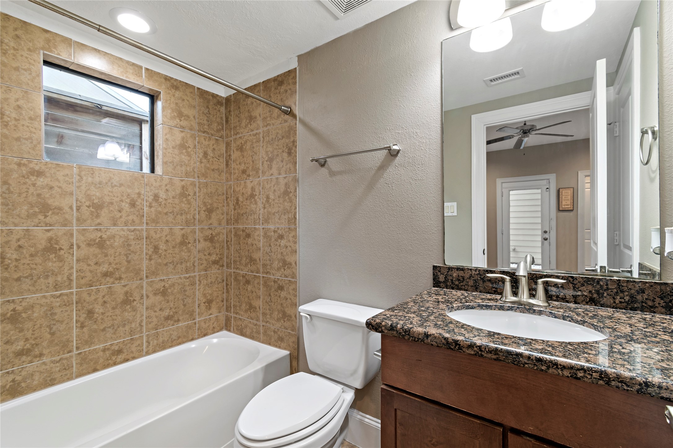 808 Paige Street Houston, TX 77003 - Photo 16 of 23 Discover the elegance of Primary Bedroom 2's bath and closet area, featuring a stylish granite-topped vanity, sleek tile accents, and a seamless connection to comfort and convenience.