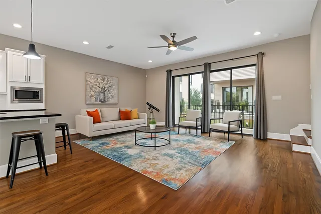 a living room with furniture and a wooden floor