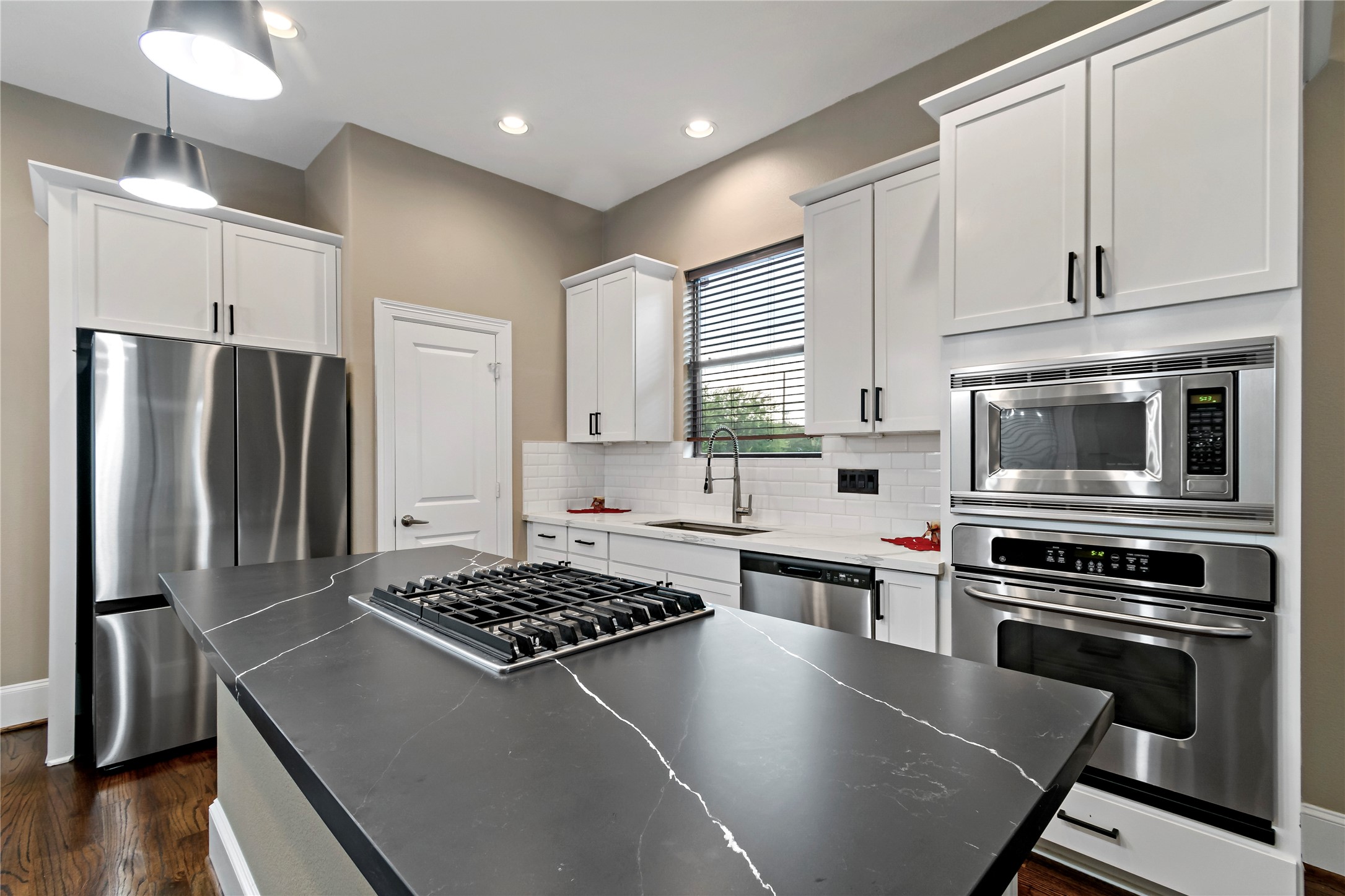 808 Paige Street Houston, TX 77003 - Photo 5 of 23 Discover the heart of your home with this stunning kitchen featuring sleek quartz countertops and modern stainless steel appliances.