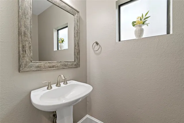 a bathroom with a sink a mirror and a window
