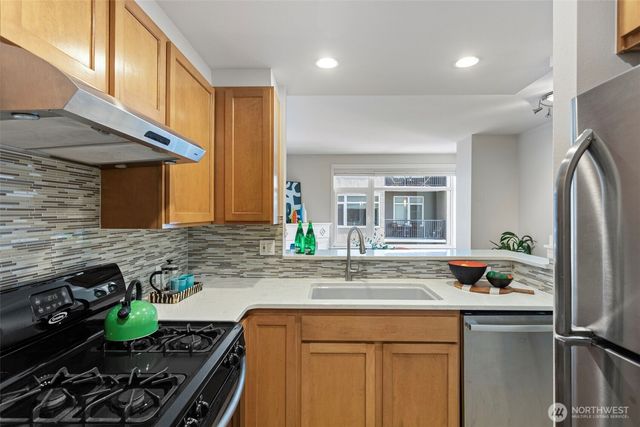 a kitchen with stainless steel appliances granite countertop a sink stove and cabinets