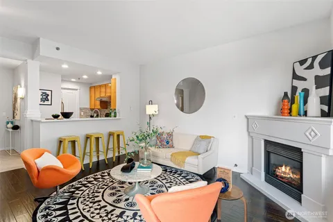 a living room with furniture and a dining table with wooden floor