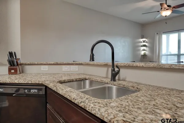 a kitchen with granite countertop a sink and a stove