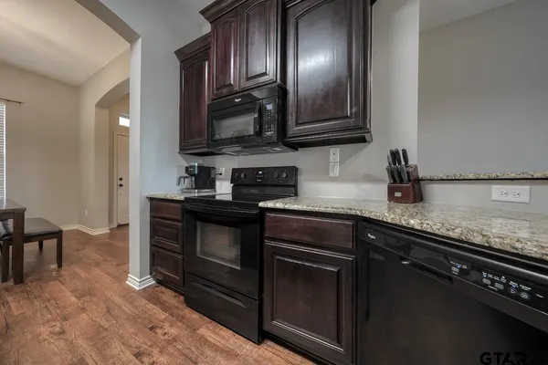 a kitchen with granite countertop stainless steel appliances and wooden cabinets