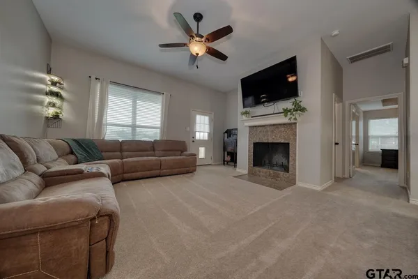 a living room with furniture a fireplace and a flat screen tv