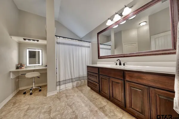 a spacious bathroom with a double vanity sink a mirror and a shower