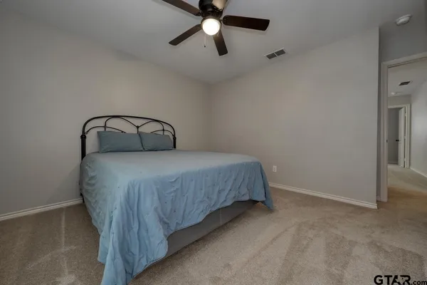a bedroom with a bed and a ceiling fan