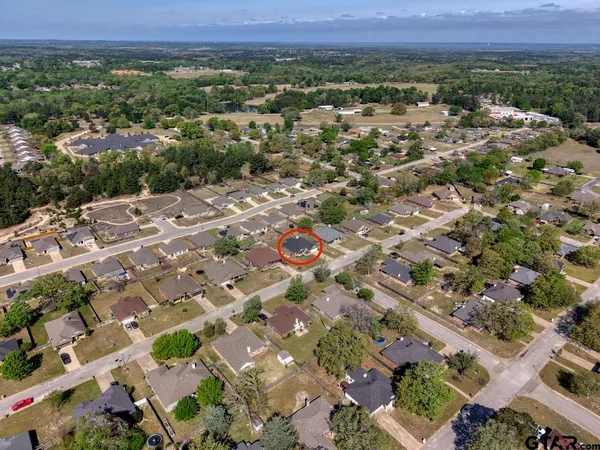 an aerial view of residential house with parking and yard