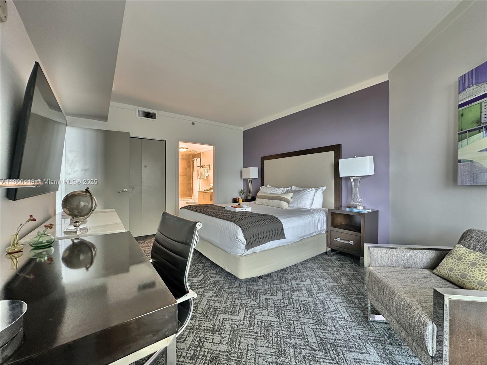 2889 McFarlane Road, Unit 1814 Miami, FL 33133 - Photo 6 of 12 a bedroom with a bed and wooden floor