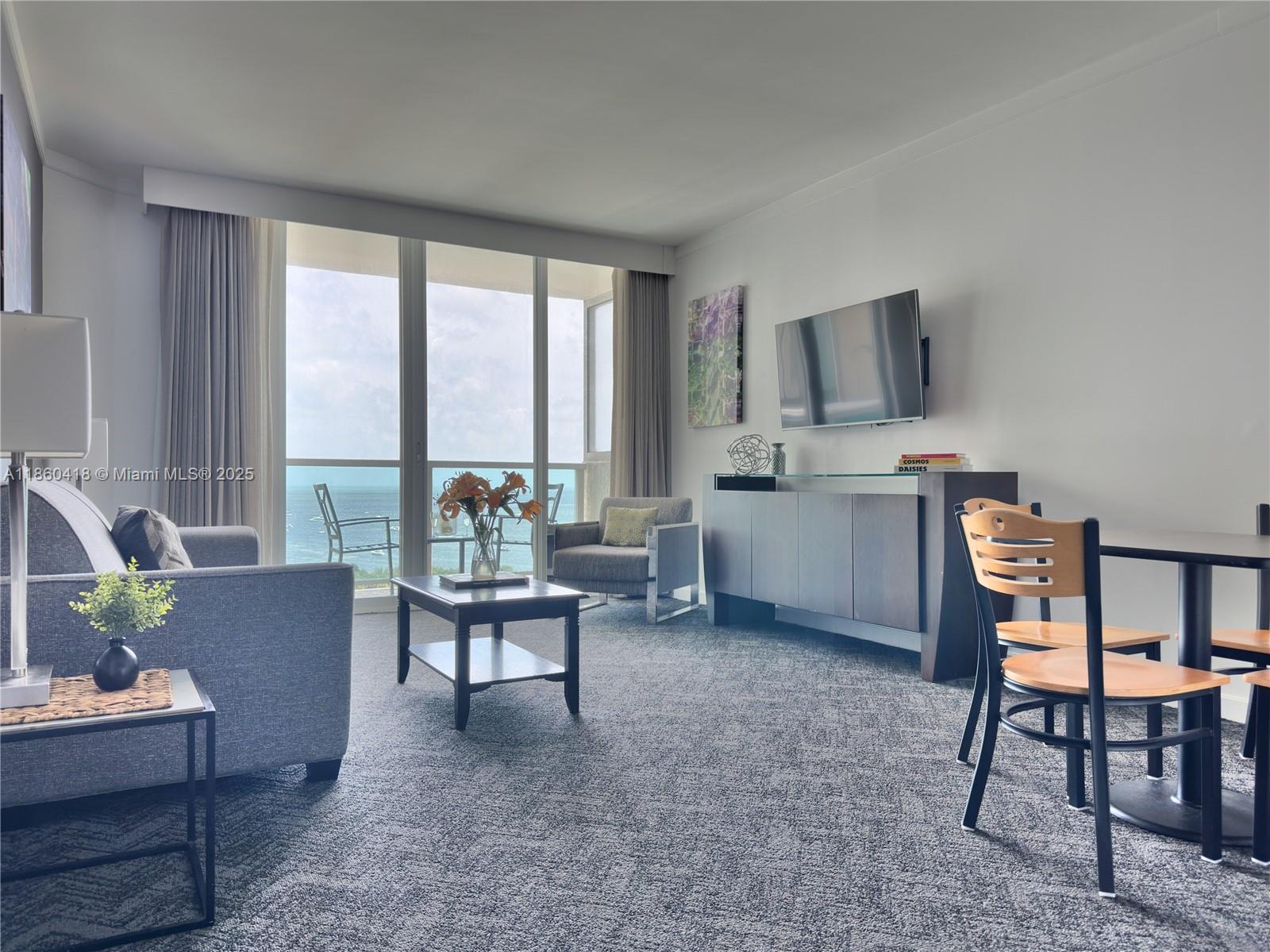 2889 McFarlane Road, Unit 1814 Miami, FL 33133 - Photo 8 of 12 a living room with furniture and a flat screen tv