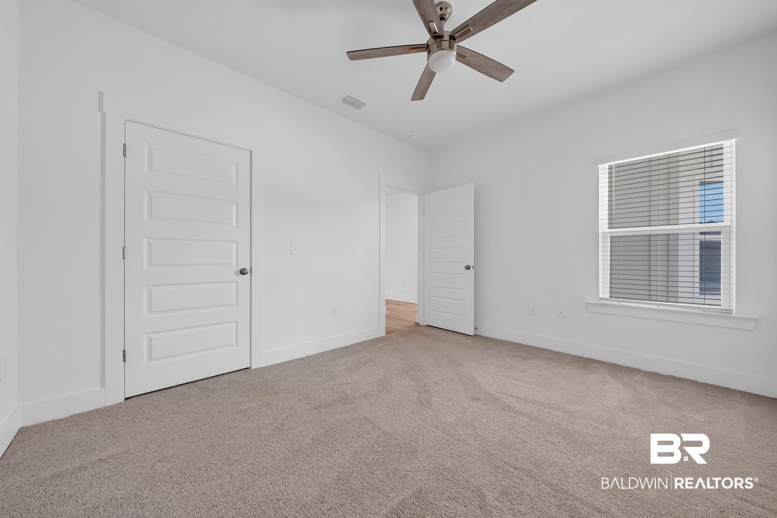 9933 Weller Cove Foley, AL 36535 - Photo 24 of 36 Light-filled room featuring neutral-toned carpet flooring, a multi-pane window with blinds, and a ceiling fan with light fixture