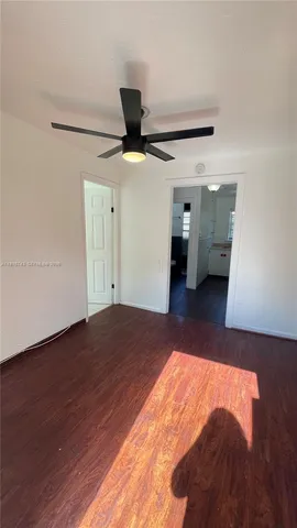 a view of a big room with wooden floor and a ceiling fan