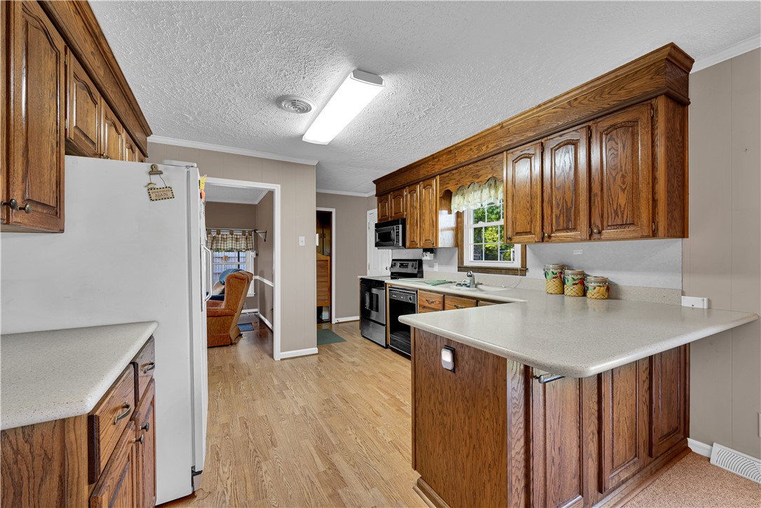 307 Calhoun Road Belton, SC 29627 - Photo 29 of 30 A functional kitchen boasts rich wooden cabinetry and ample counter space, creating a welcoming culinary area.