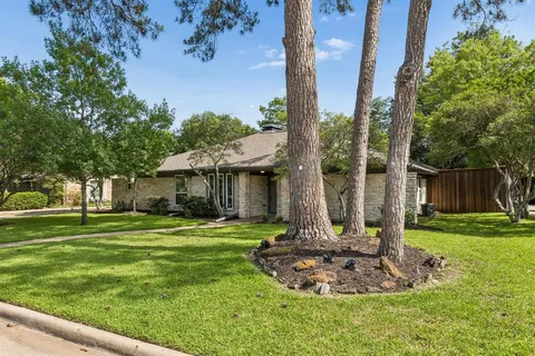 a view of a house with a backyard and tree