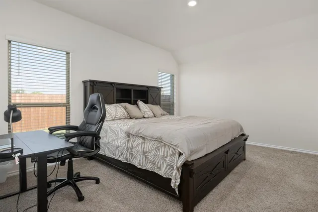 a bed sitting in a bedroom next to a window