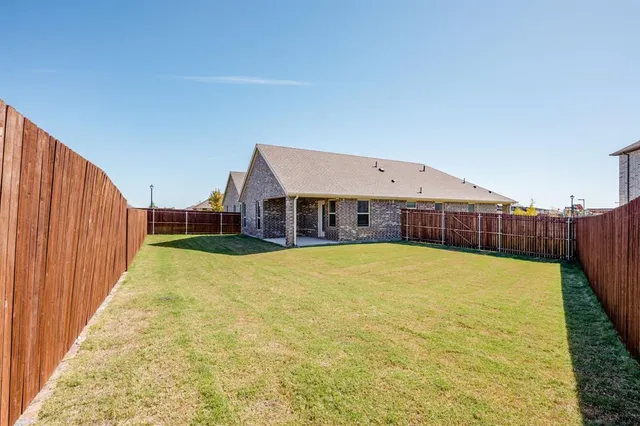 a view of a swimming pool with deck and a yard