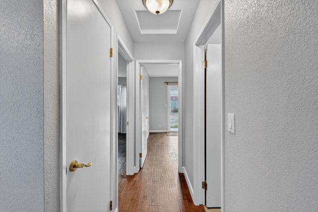 a view of a hallway with wooden floor and closet