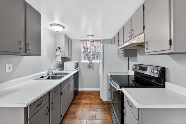a kitchen with a sink stove top oven and cabinets