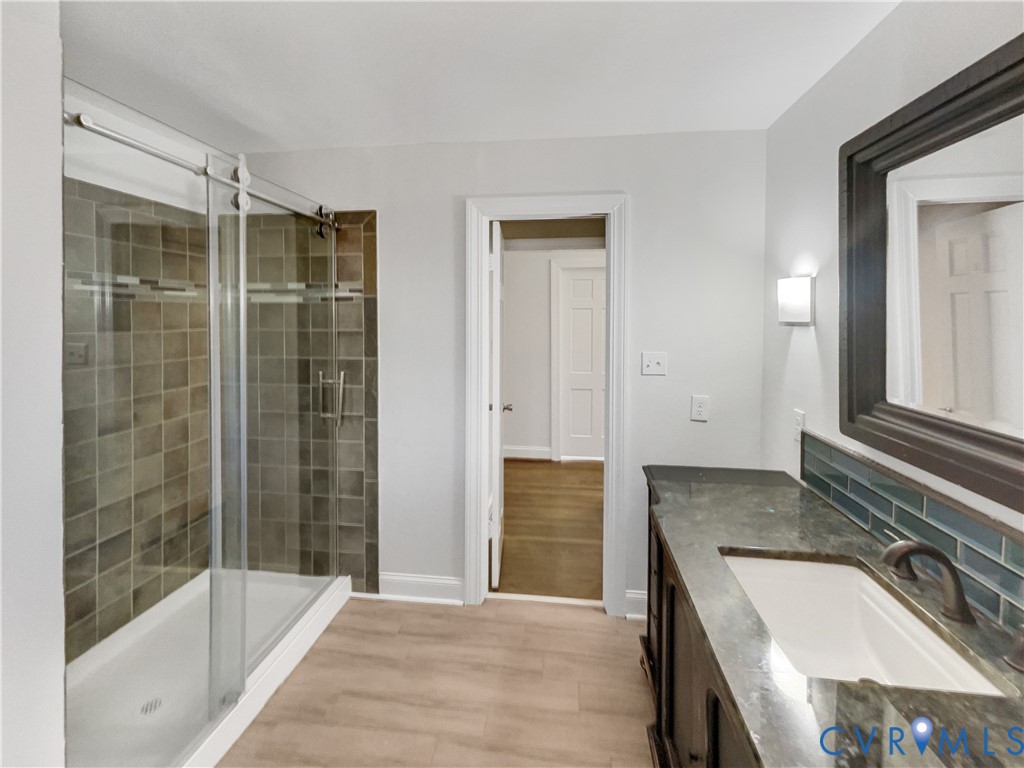 310 Burnwick Road Richmond, VA 23227 - Photo 16 of 21 a bathroom with a granite countertop sink a mirror and a bathtub