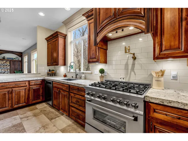 a kitchen with stainless steel appliances granite countertop wooden cabinets a sink and a stove