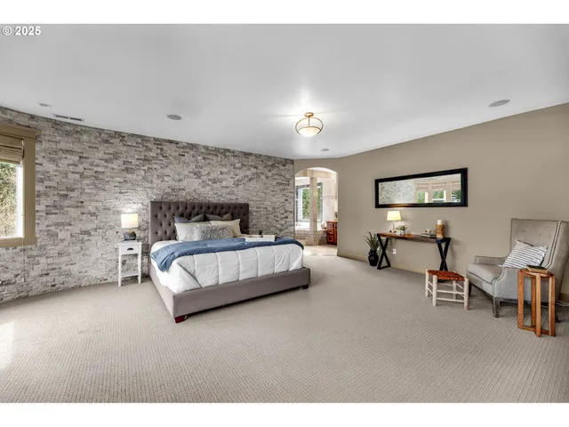 a spacious bedroom with a bed and a chandelier