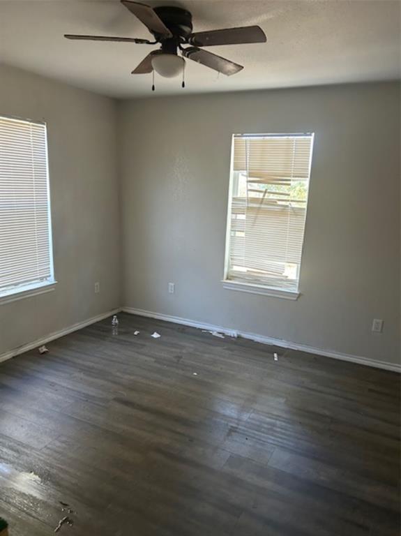 307 South Jernigan Street Bells, TX 75414 - Photo 10 of 10 an empty room with wooden floor chandelier fan and windows