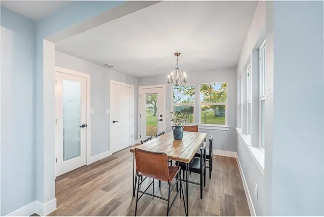 a view of a dining room with furniture a chandelier and wooden floor