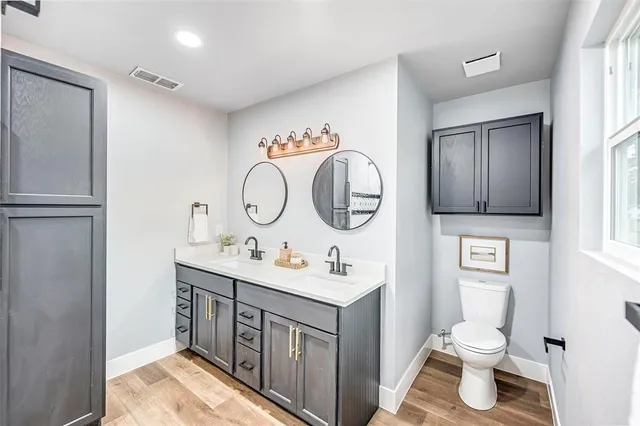 a bathroom with a toilet a sink and a mirror