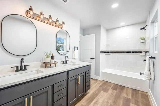 a bathroom with a double vanity sink mirror and shower