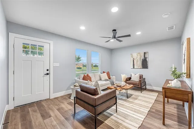 a living room with furniture and a ceiling fan