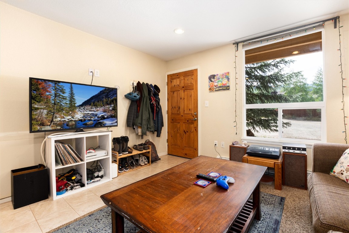 163 High Tor Road, Unit 2 Breckenridge, CO 80424 - Photo 23 of 48 a living room with furniture a flat screen tv and a table