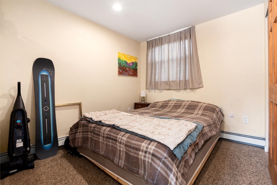 163 High Tor Road, Unit 2 Breckenridge, CO 80424 - Photo 29 of 48 a bedroom with a bed and a flat tv screen on a dresser