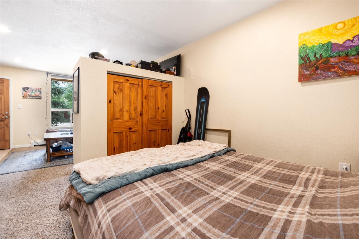 163 High Tor Road, Unit 2 Breckenridge, CO 80424 - Photo 30 of 48 a bedroom with a bed and a flat screen tv