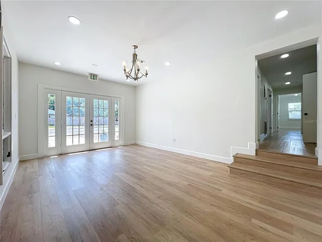 a kitchen with stainless steel appliances a dining table chairs and wooden floor