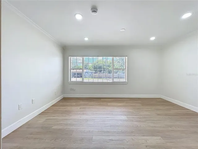 a view of an empty room with wooden floor