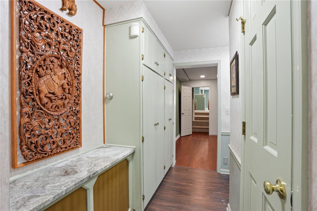 6271 Batman Road Zionsville, PA 18092 - Photo 42 of 100 Hardwood floors guide you through this inviting hallway, revealing a staircase in the distance.