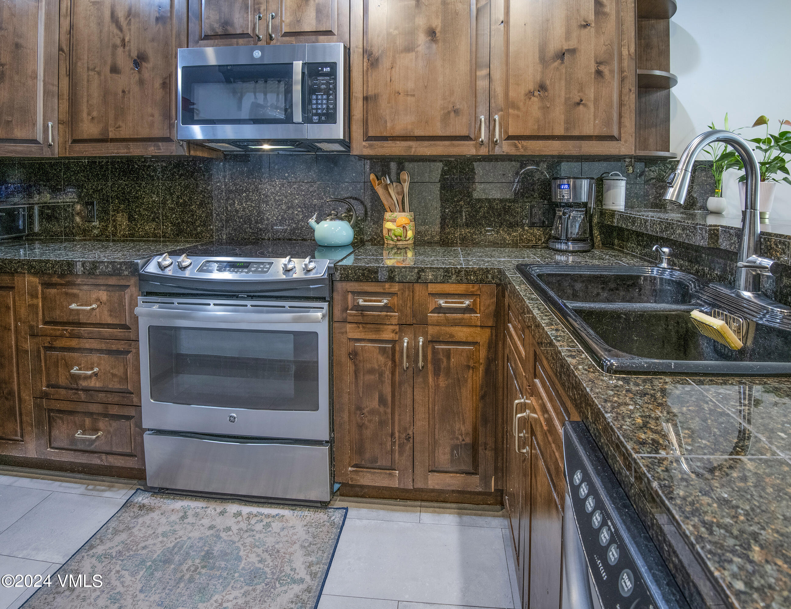 600 Nottingham Road, Unit 5 Avon, CO 81620 - Photo 3 of 13 a kitchen with granite countertop a stove top oven microwave and cabinets